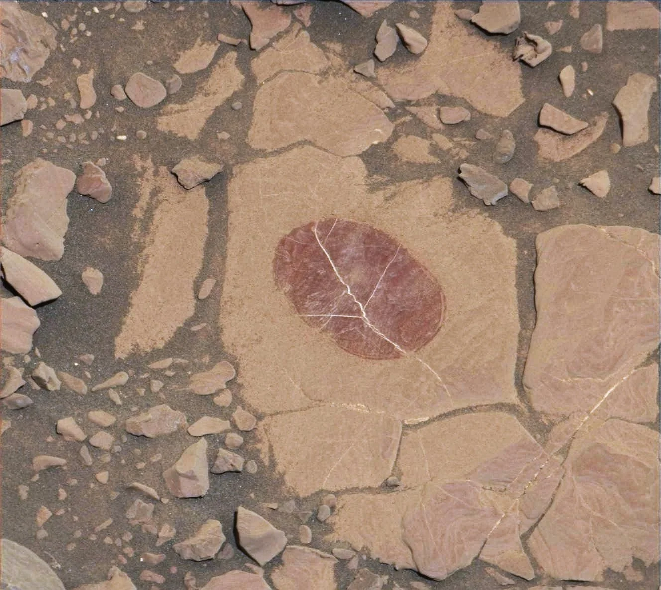 A series of red rocks with a dark circular mark in the middle.